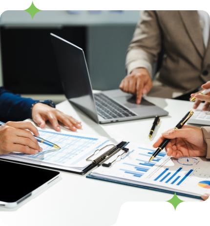 A team of advisors discussing with a laptop and growth charts.