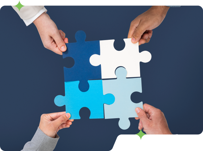 A team holding solved puzzle pieces in their hands represents teamwork and business cooperation.